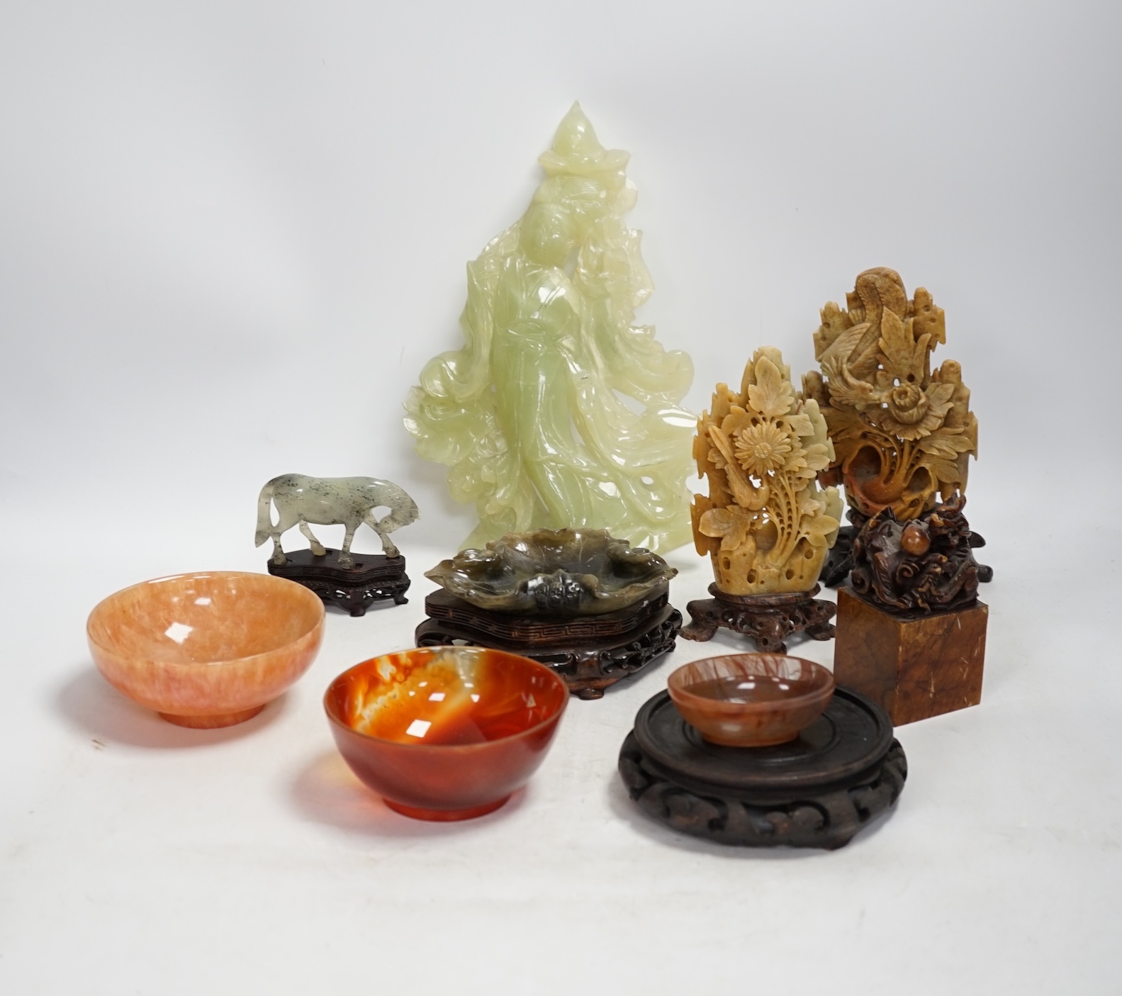 A group of nine Chinese hardstone and soapstone figures, tallest 26cm. Condition - fair